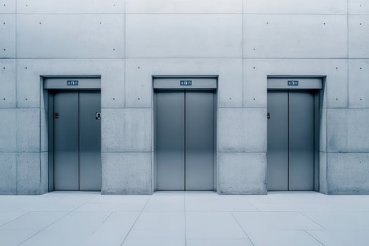 Elevator doors feature a sleek, minimalist design set against a smooth concrete wall, creating a modern atmosphere in a contemporary building. photo