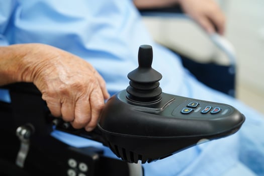 Asian elderly disability woman patient use joystick electric wheelchair in hospital. photo