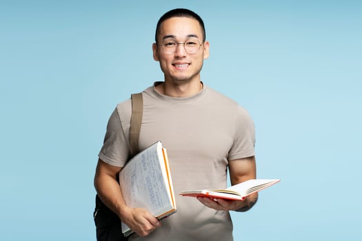 Young student smiling holding books and wearing backpack photo