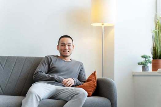 Young man smiling while relaxing on couch at home photo