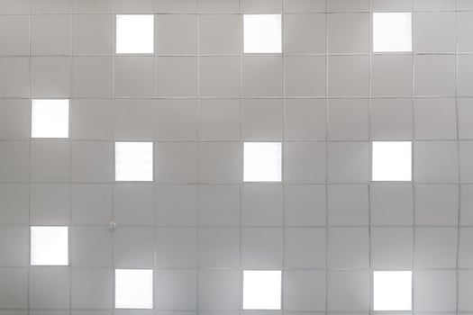 cassette stretched or suspended ceiling with square halogen spots lamps and drywall construction in empty room in house or office. Looking up view photo