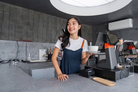 Beautiful Barista Making Coffee in a Modern Cafe with a Smile, Wearing Casual Attire, and Using Professional Equipment photo