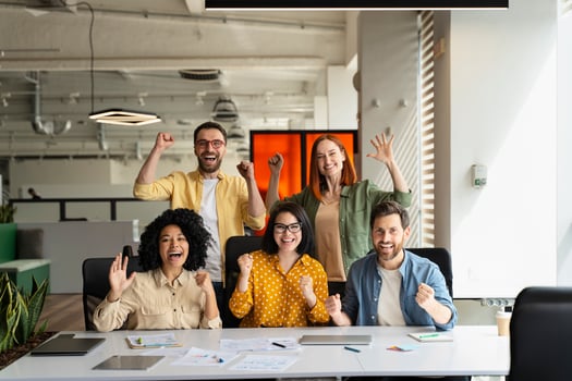 Happy excited business team celebrating success, cheering and yelling at workplace photo