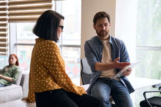 Businessman showing digital tablet to female colleague during meeting photo