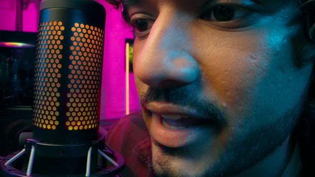 Close up Indian Arabian Muslim man streamer player game cyber sport male microphone mic recording broadcasting guy mouth scream emotions shout computer influence blog radio presenter technology photo
