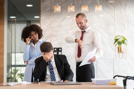 Frustrated diverse business team with paperwork at office desk, Concept of workplace stress photo