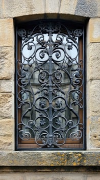 Old european window reflecting building with ornate iron grillwork photo