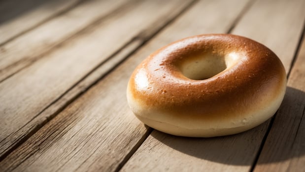 A bagel sitting on top of a wooden table photo