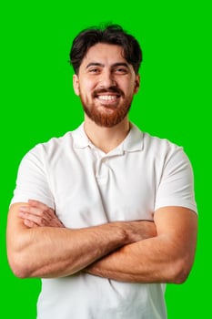 A smiling young man with a beard poses against a bright green background photo