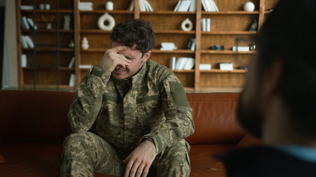 Worried depressed frustrated Caucasian sad despair patient man male client guy military combat uniform army soldier officer holding head pain talking to psychologist war stress crisis office therapy photo