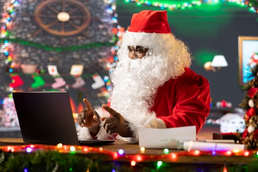African american Father Christmas meeting with parents on online call before the winter holiday, collecting gifts ideas to make kids happy. Black Santa using technology during x mas time. photo