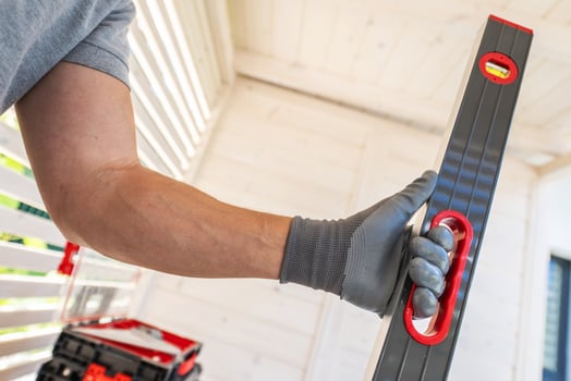 A Worker Using a Leveling Tool in a Well-Lit Indoor Space to Ensure Precise Alignment photo