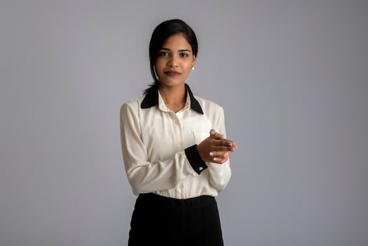 Young Indian girl using a mobile phone or smartphone on gray background photo