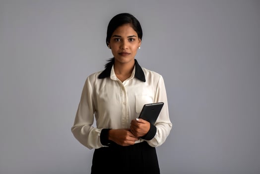Young Indian girl using a mobile phone or smartphone on gray background photo