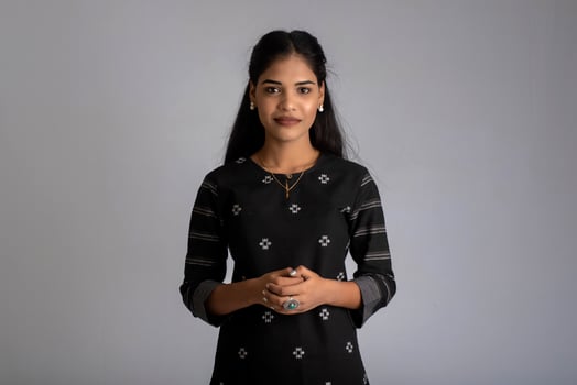 Portrait of a young beautiful cute cheerful girl smiling looking at the camera on gray background photo