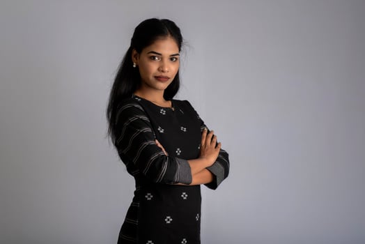 Portrait of a young beautiful cute cheerful girl smiling looking at the camera on gray background photo