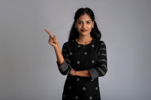 Beautiful girl holding and presenting something in the hand with a happy smiling face. photo