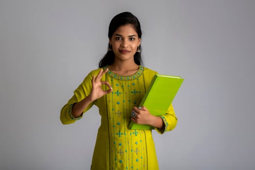 Pretty young girl posing with the book on grey background photo