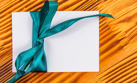 Blank note with green ribbon wooden , concept photo