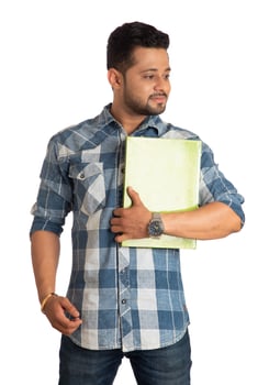 Young happy man holding and posing with the book on white background. photo