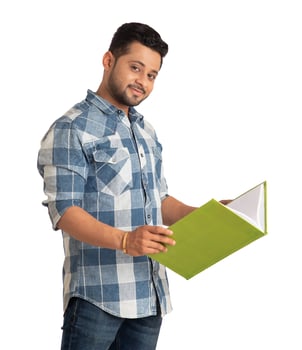 Young happy man holding and posing with the book on white background. photo