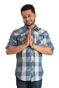Young Indian man with welcome expression or inviting or greeting Namaste on a white background photo