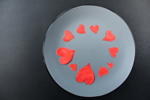 red hearts on a plate of gray on a black background with a copyspace place for text photo