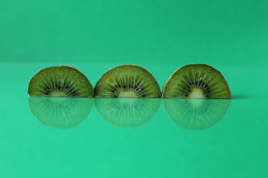 Green still life circles semicircular kiwi pieces with flipped on green with copyspace photo