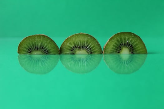Green still life circles semicircular kiwi pieces with flipped on green with copyspace photo