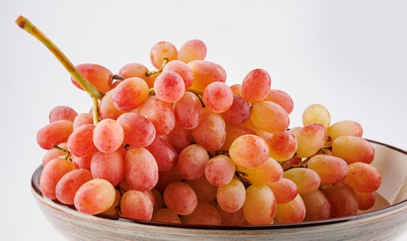 A juicy beautiful bunch of grapes lies in a plate. photo