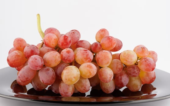 A juicy beautiful bunch of grapes lies in a plate. photo