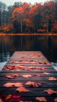Autumn sunset reflects on calm lake with wooden dock covered in red leaves photo