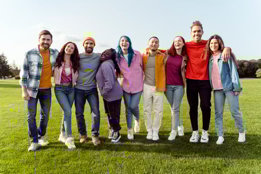 Group of nine young adults smiling and having fun together in a park photo