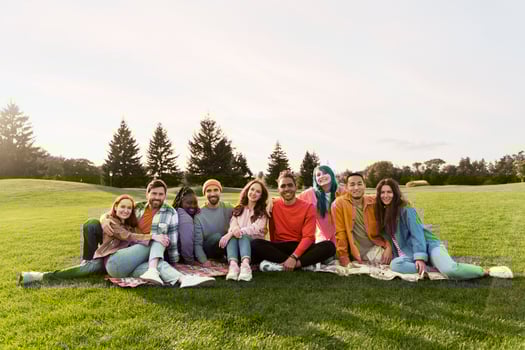 Diverse group of people posing together outdoors in the park photo