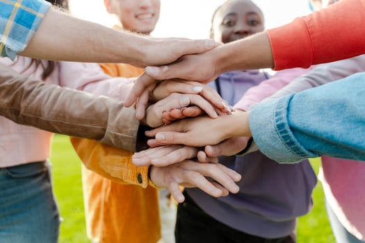 Group of people joining hands in teamwork gesture photo