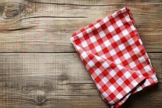 A red and white checkered napkin on a wooden table photo