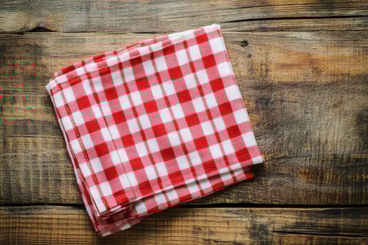 A red and white checkered napkin on a wooden table photo