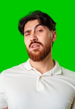 A young man with a beard showing a serious expression against a vibrant green background photo