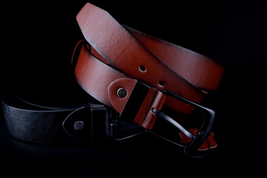 Brown and black leather belts on a black background. photo