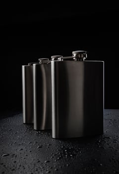 Stainless steel flasks on a black background with water drops. photo