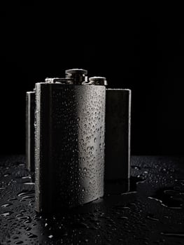 Stainless steel flasks on a black background with water drops. photo