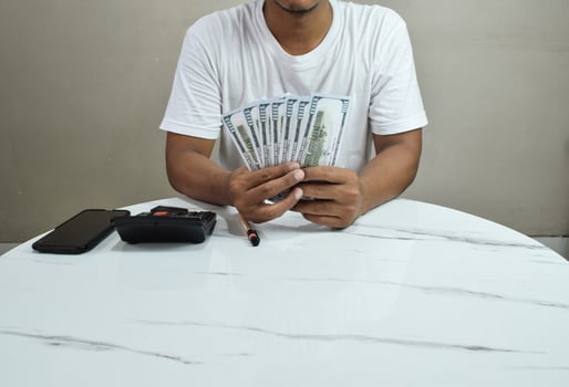 Businessman's hand holding one hundred dollar bill, investment and finance in mobile applications, trading on mobile phone. photo