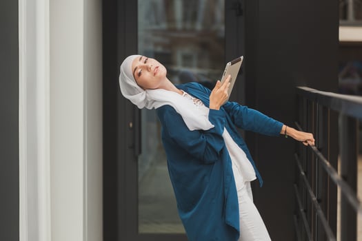Beautiful Asian businesswomen wearing hijab using her tablet at outdoor. photo