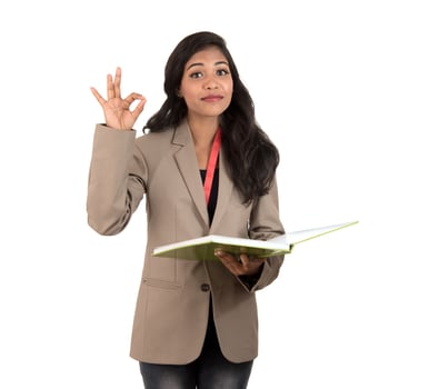 thoughtful woman student, teacher or business lady holding books and showing ok sign on white background photo