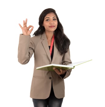 thoughtful woman student, teacher or business lady holding books and showing ok sign on white background photo