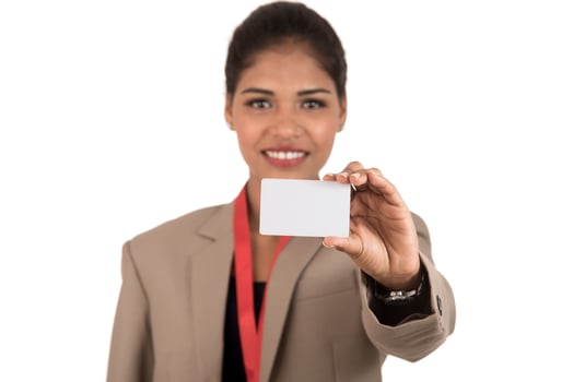 Smiling business woman holding a blank business card or ID card over white background photo