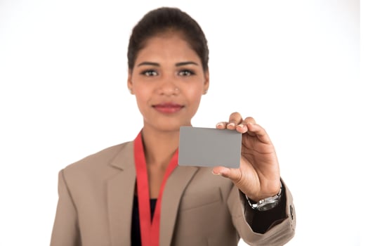 Smiling business woman holding a blank business card or ID card over white background photo