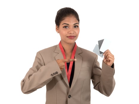 Smiling business woman holding a blank business card or ID card over white background photo