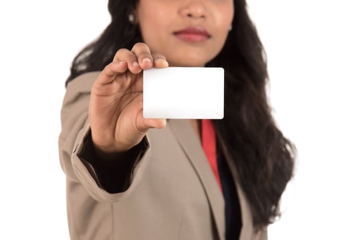 Smiling business woman holding a blank business card or ID card over white background photo