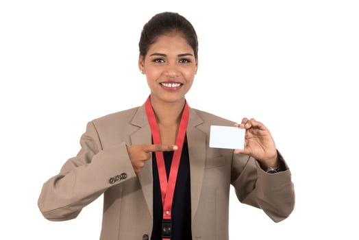 Smiling business woman holding a blank business card or ID card over white background photo
